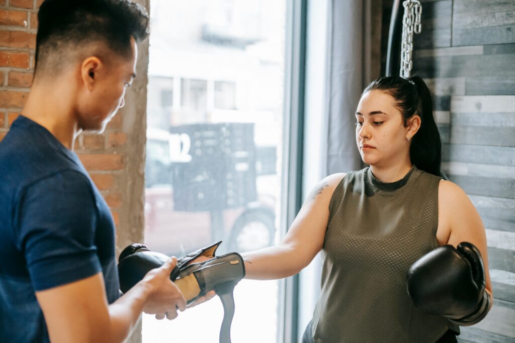 women putting on boxing gloves